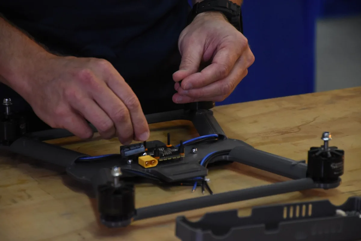 Hands assembling a Remora airframe at the workbench